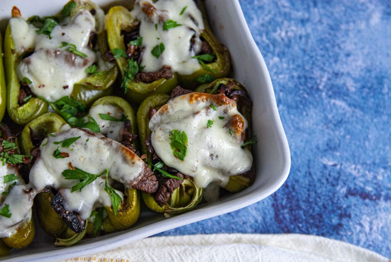 Casserole dish showing 4 philly cheesesteak stuffed peppers