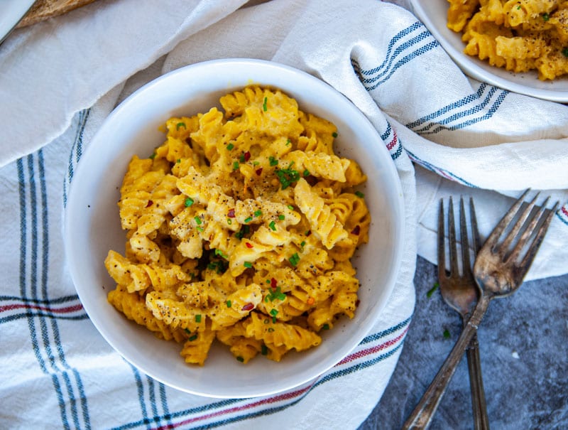 One bowl of pumpkin mac and cheese in a white bowl