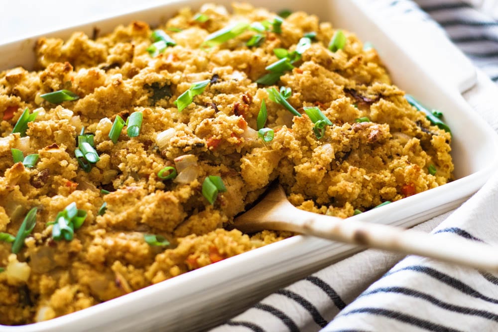 Side view of Southwest Cornbread Dressing Recipe with wooden spoon 